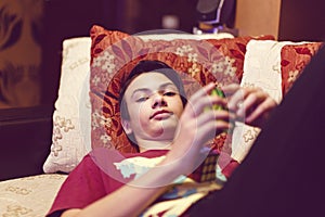 A boy sitting on the couch and playing