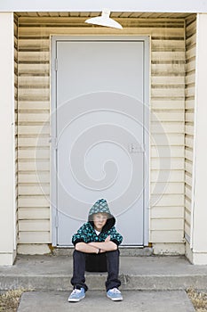 Boy Sitting on a Curb