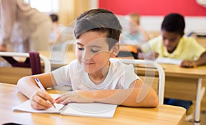 Boy sitting at desk studying in classroom