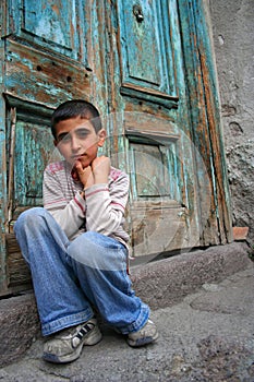 A boy sitting at the doorstep