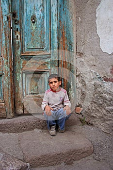 a boy sitting at the doorstep