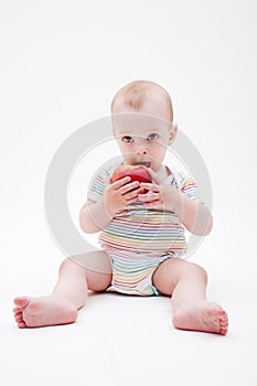 Boy sitting on the floor and eating apple