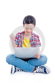 Boy sitting on the floor and playing games on laptop