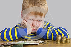 Boy sitting in front of a lot of money