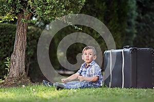Boy sitting on the grass in the park