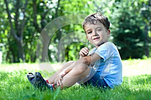 boy, sitting on grass, smelling flower