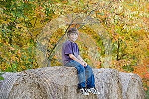 Boy Sitting on Hay Bales