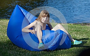 Boy Sitting in an Inflatable Plastic Lounger.