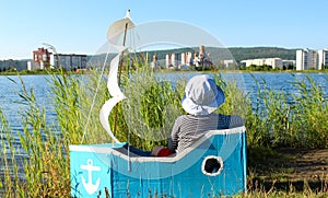 The boy is sitting in a makeshift ship