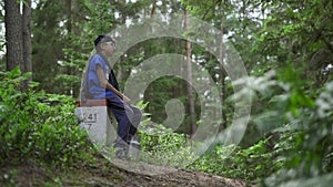 Boy sitting  in the middle of the forest and cries for help screaming echo