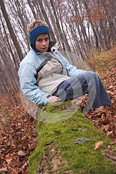 boy sitting on mossy log