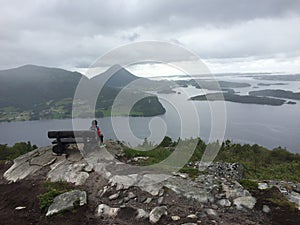 Boy sitting on the Mountain taking a break and enjoying the view