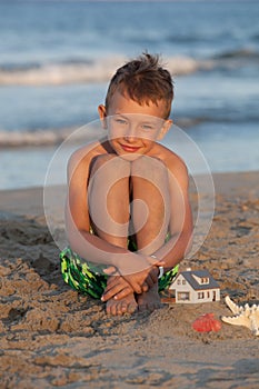 Boy sitting in the sandy beach
