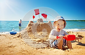 Boy sitting smiling at the beach