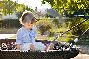 Boy sitting on a swing in the park