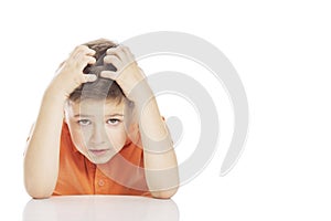 The boy is sitting at the table, holding his head with his hands. Close-up, free space for text. Isolated on a white background