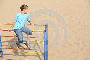 A boy sitting at the top of playground