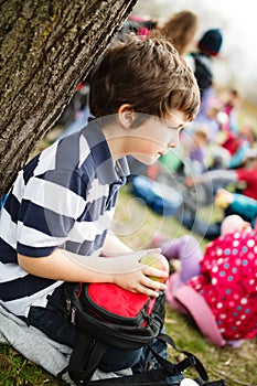 Boy sitting by a tree