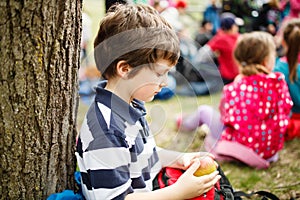 Boy sitting by a tree