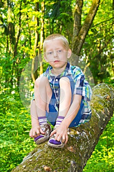 Boy sitting by a tree