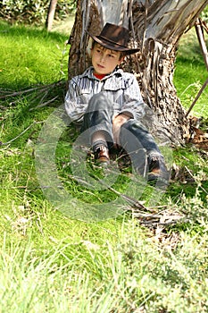 Boy sitting under a gum tree