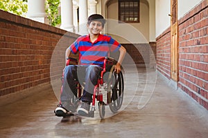 Boy sitting in wheelchair in school corridor