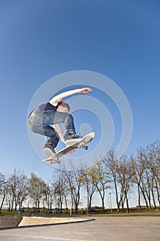 Boy with skate board is going airborne photo