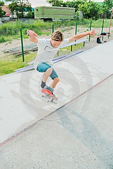 A boy in a skate park doing a trick on a skateboard