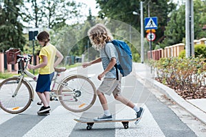 Boy on a skateboard and a girl with a bicycle