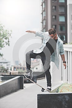 Boy skater is doing stunt at the street