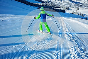 Boy ski downhill fast the fresh track view from behind