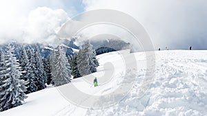 Boy ski off piste downhill with beautiful snow forest on back