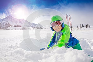 Boy with ski play in fresh deep snow smiling