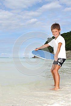 Boy with skim board on sea background photo