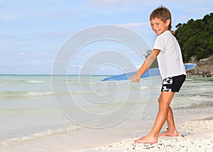 Boy with skim board on sea background