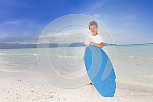 Boy with skim board on sea background