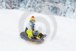 Boy on sled ride. Child sledding. Kid on sledge