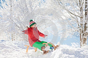 Boy on sled ride. Child sledding. Kid on sledge