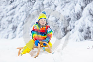 Boy on sled ride. Child sledding. Kid on sledge