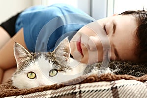 Boy sleep beside pet siberian male cat