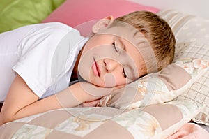 boy sleeping on the bed in pillows