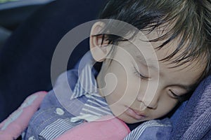 boy sleeping in child car seat