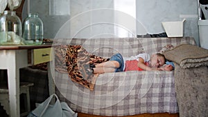 Boy sleeping on a sofa in a country house