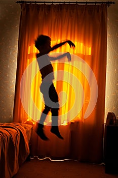 Boy sleepwalker jumping from bed photo