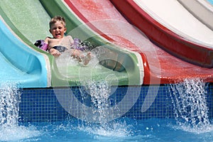 The boy slides a waterslide.