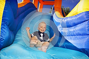 Boy sliding down an inflatable Slide