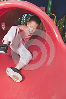 Boy sliding on playground