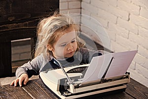 Boy or small kid with typewriter and paper