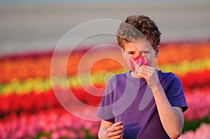 Boy smelling flower