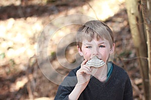 Boy smelling a scaly polypore